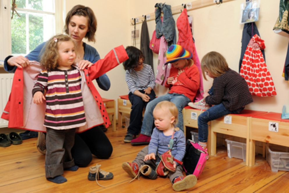 Erzieherin und Kinder in einer Kita beim Anziehen. Bildnachweis: Meike Gronau