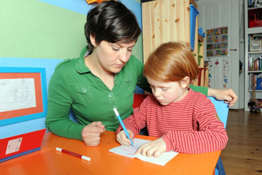 Eine Mutter übt mit ihrem Schreiben. Bildquelle: BMFSFJ / Meike Gronau