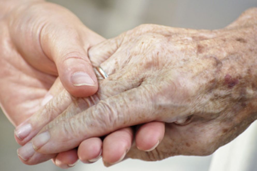 Die Hand eines jungen Menschen hält die Hand eines älteren Menschen. Bildquelle: istock