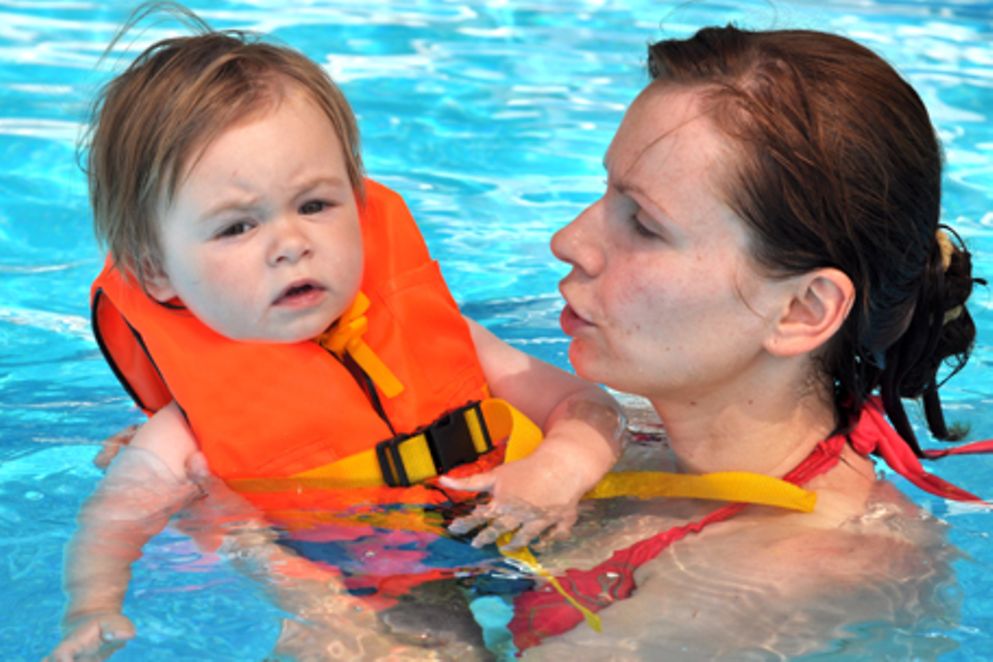Eine Mutter und ihr Kind mit Schwimmweste in einem Schwimmbad. Bildquelle: iStockphoto