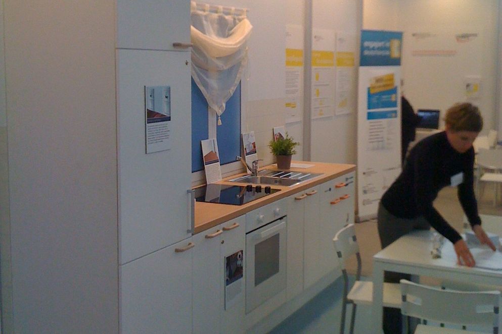 Eine Ausstellungsküche mit einer Besucherin.