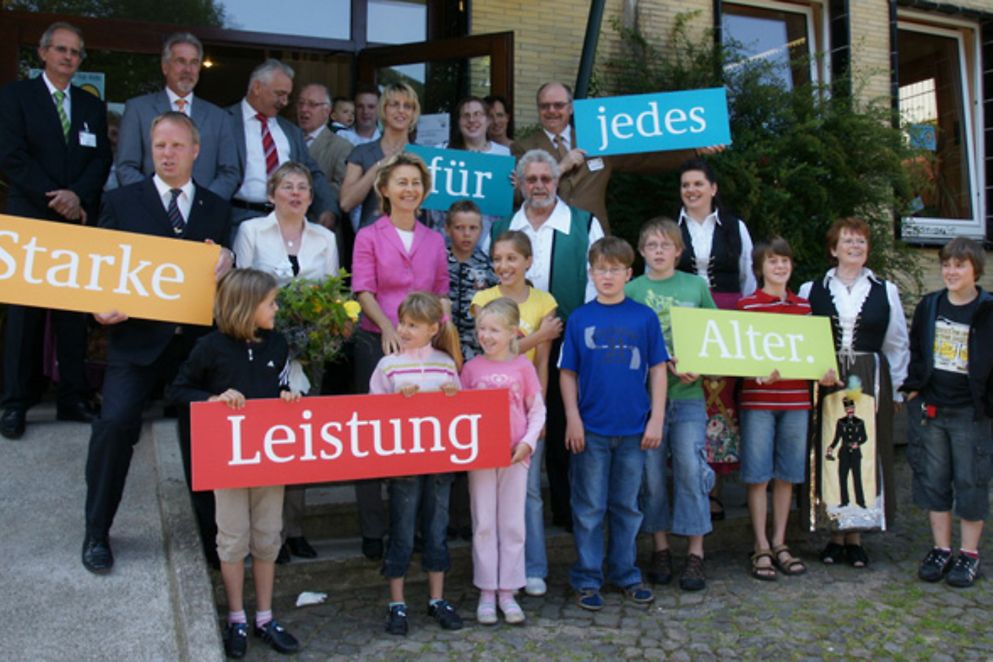 Foto: Ursula von der Leyen im Gruppenbild vor dem Mehrgenerationenhaus in Osterode.