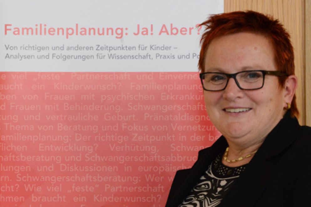 Elke Ferner vor dem Plakat zur Konferenz "Familienplanung: Ja! Aber?", Bildnachweis: BMFSFJ