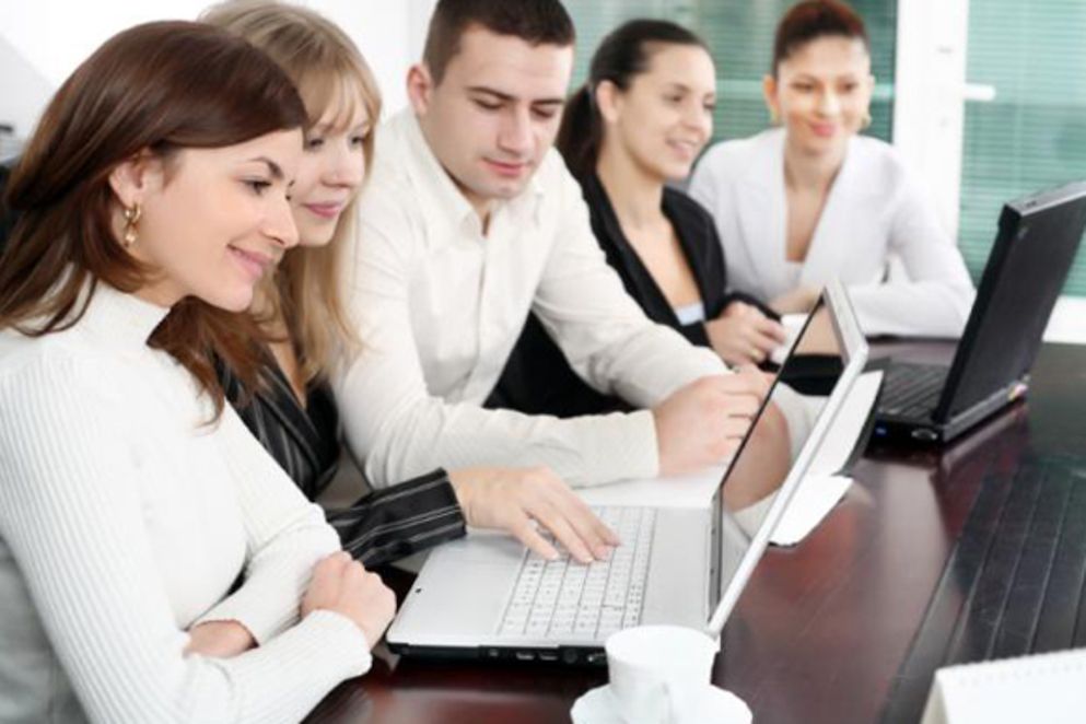 Frauen und Männer arbeiten gemeinsam an ihren Laptops, Bildnachweis: iStock
