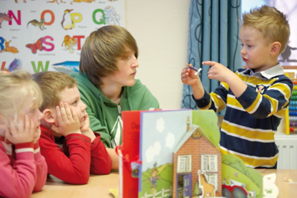 Ein Jugendlicher und drei Kinder in einer Kita. Bildquelle: www.boys-day.de
