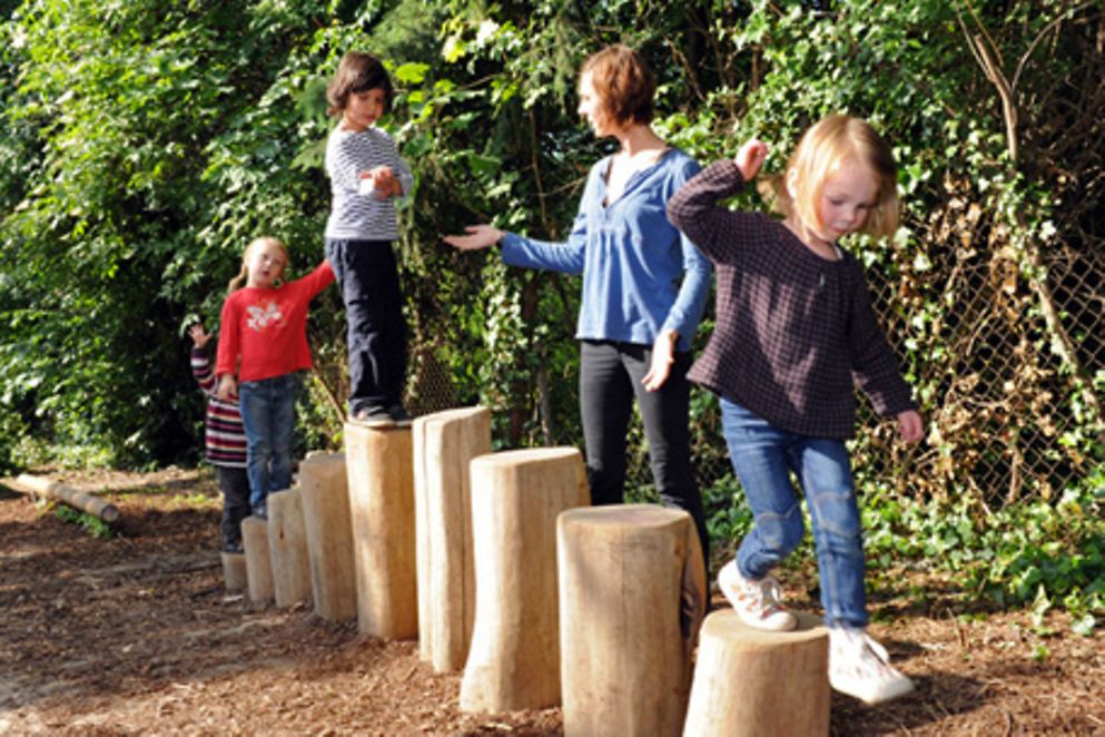 Eine Kita-Betreuerin mit mehreren Kindern auf einem Spielplatz. Bildquelle: M. Gronau / BMFSFJ