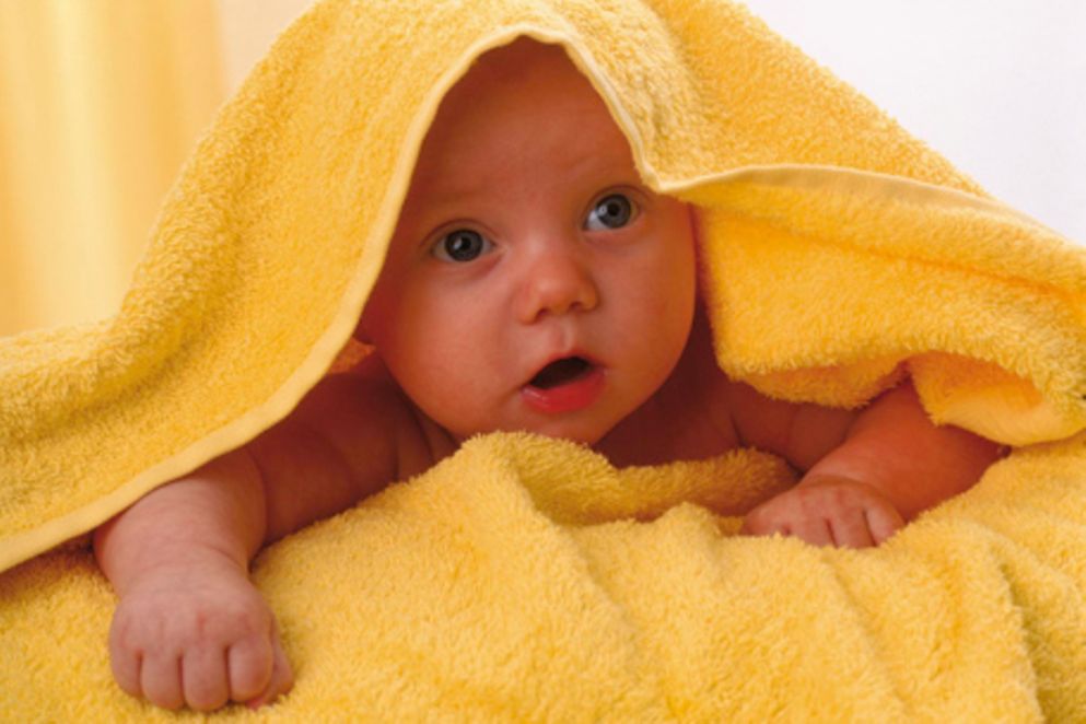 Ein Baby unter einem Handtuch.