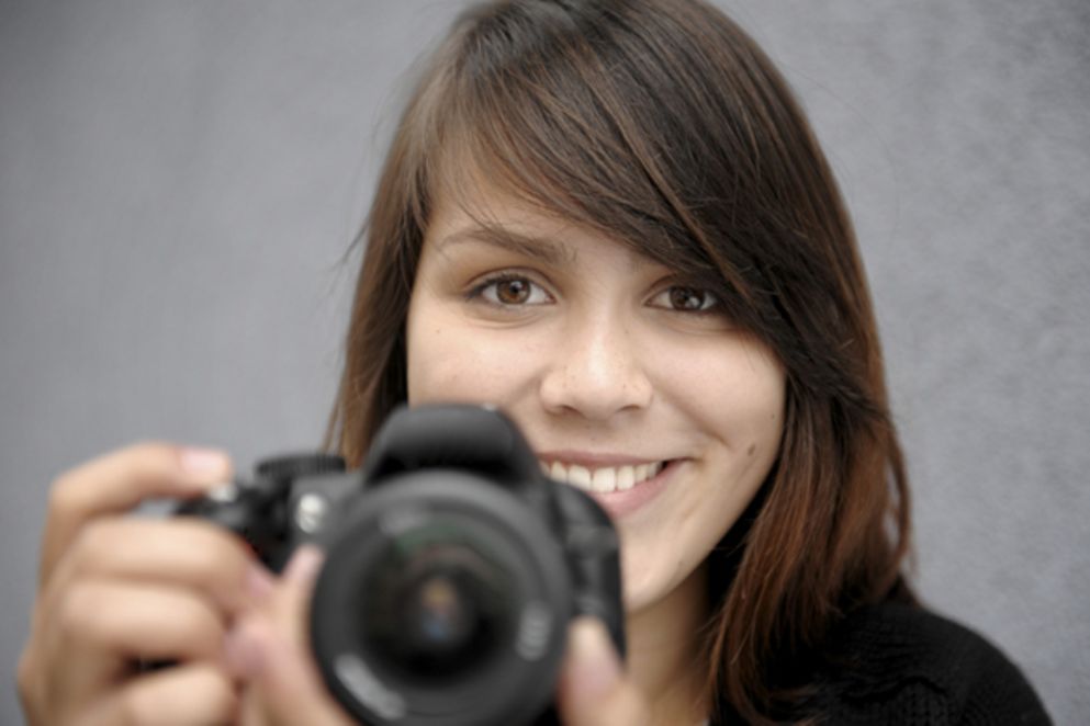Eine junge Frau mit einer Kamera in der Hand