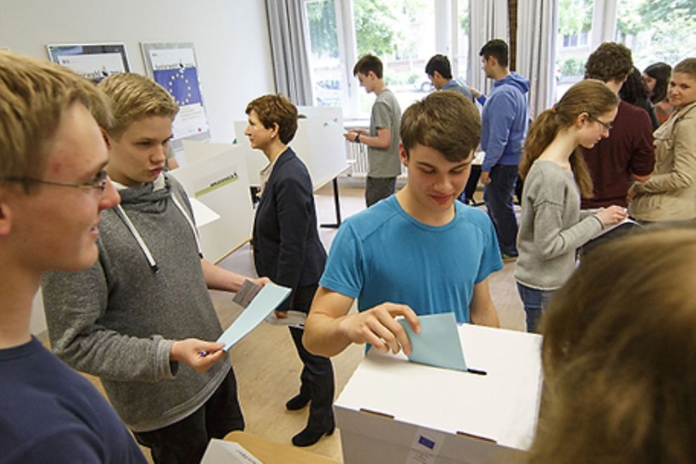 Ein Schüler wirft seinen Wahlzettel in eine Wahlurne, Bildnachweis: Carsten Koall