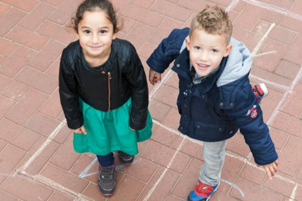 Spielende Kinder schauen lachend in die Kamera