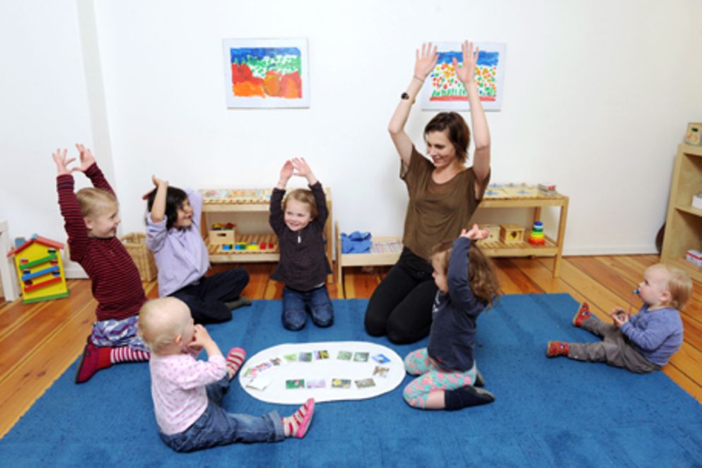 Erzieherin sitzt mit Kindern im Kreis. Bildnachweis: BMFSFJ