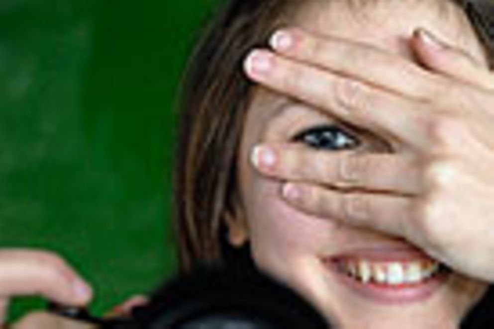 Logo des Deutschen Jugendfotopreises 2014: Auf dem Logo ist eine junge Frau, die in ihrer rechten Hand eine Fotokamera hält.