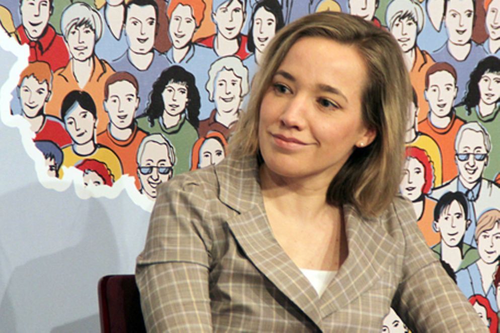 Kristina Schröder sitzt vor dem Logo zum Aktionstag "Wir für Demokratie". Bildnachweis: BMFSFJ
