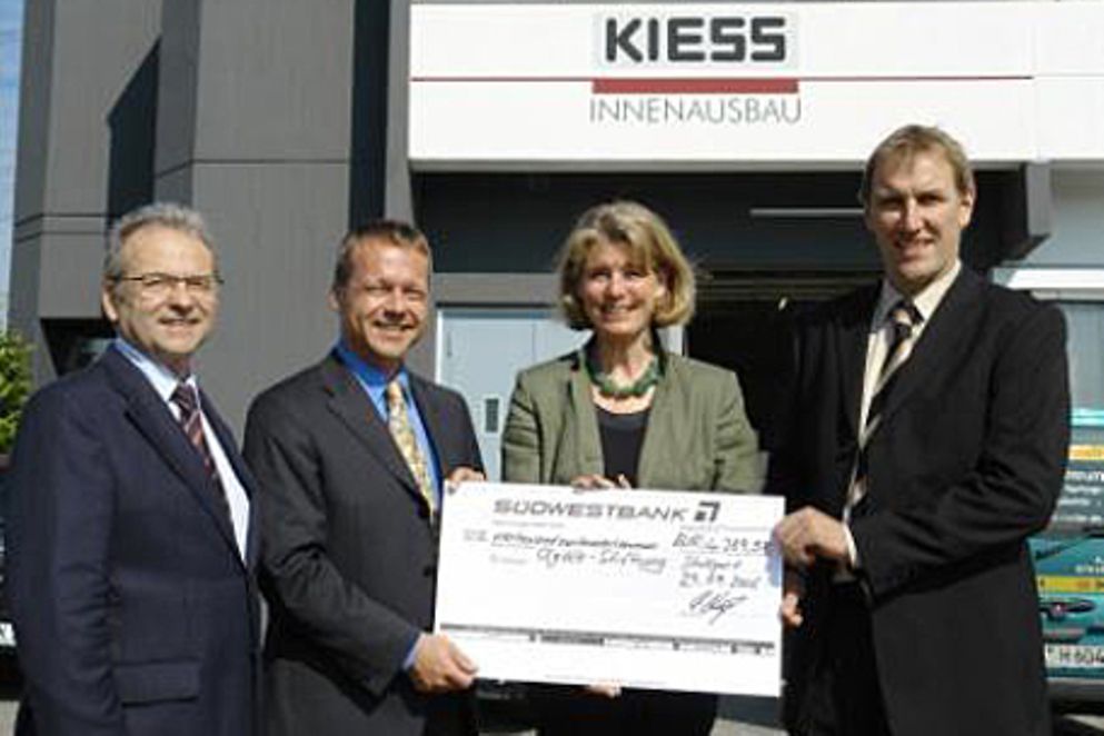Mitarbeiter der Alfred Kiess GmbH halten einen symbolischen Scheck hoch