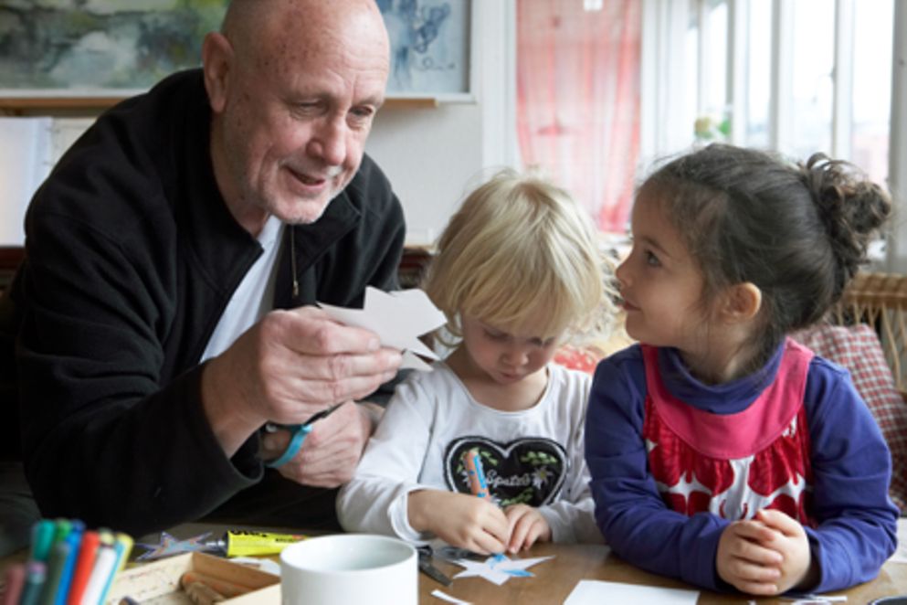 Ein älterer Mann bastelt mit zwei Kindern