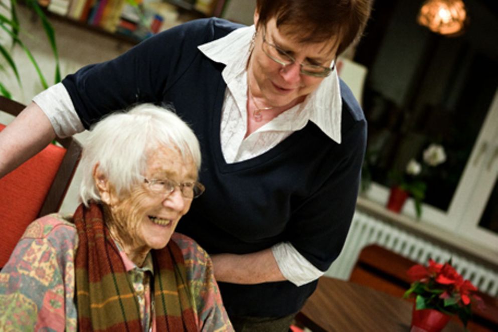 Eine ältere Frau hilft einer Seniorin im Rollstuhl. Bildquelle: BMFSFJ / Bertram Hoekstra