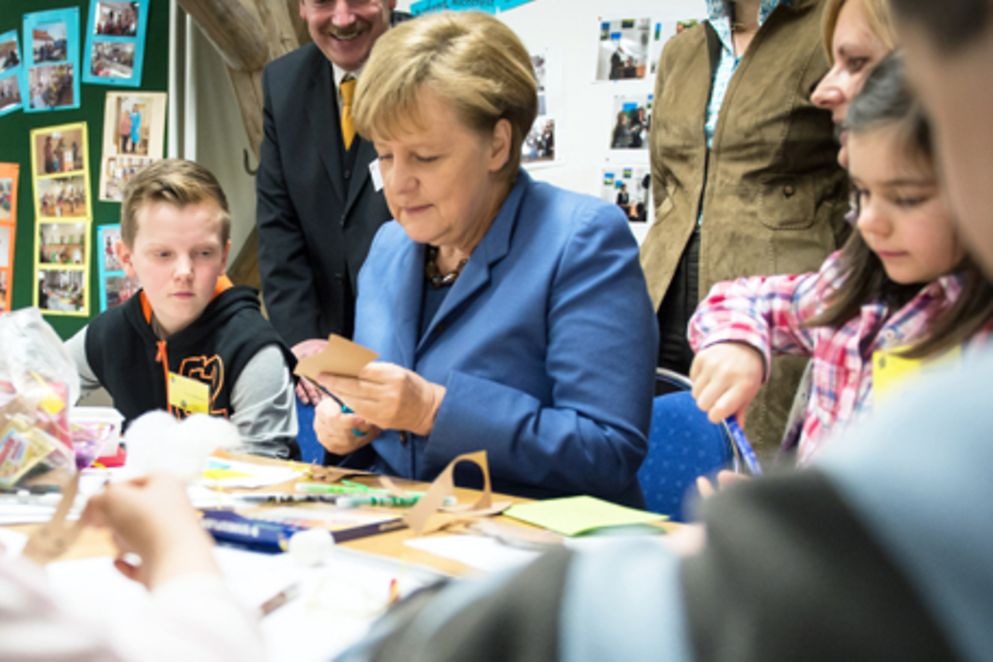 Angela Merkel beim Basteln mit Kindern im MGH. Bildquelle: Bildnachweis: Bundesregierung / Guido Bergmann