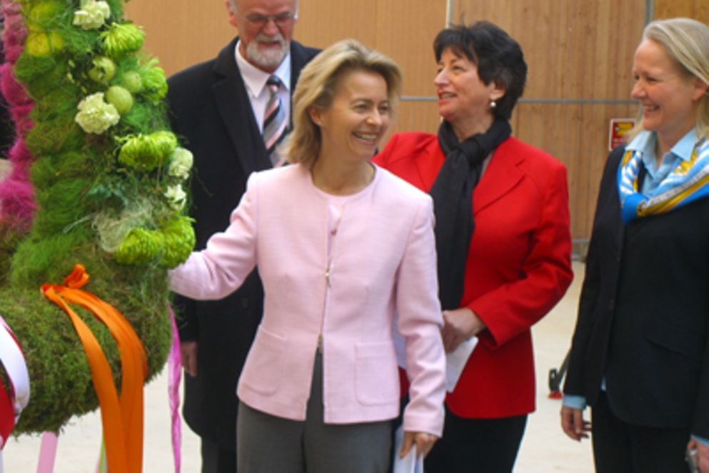 Ursula von der Leyen steht neben der Richtkrone im Rohbau des neuen Ministeriums.