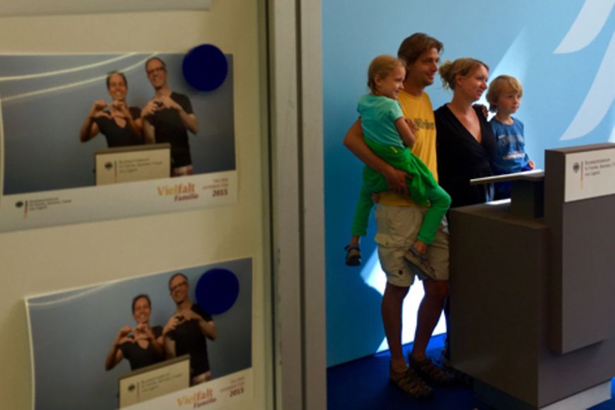 Familie lässt sich vor Pressewand fotografieren.