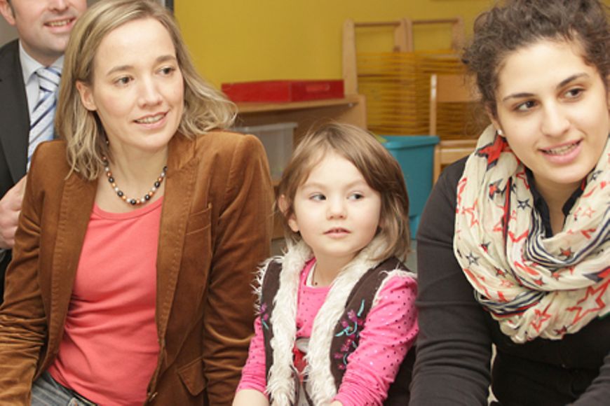 Bundesfamilienministerin Kristina Schröder mit einem Kind und einer Frau