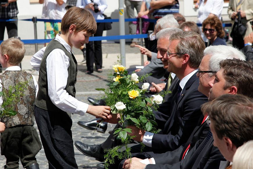 Bundespräsident Christian Wulff erhält einen Blumengruß. Bildquelle: BMFSFJ.
