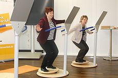 Zwei Frauen balancieren auf einem Rückentrainingsgerät mit ausgebreiteten Armen, Bildnachweis: BMFSFJ