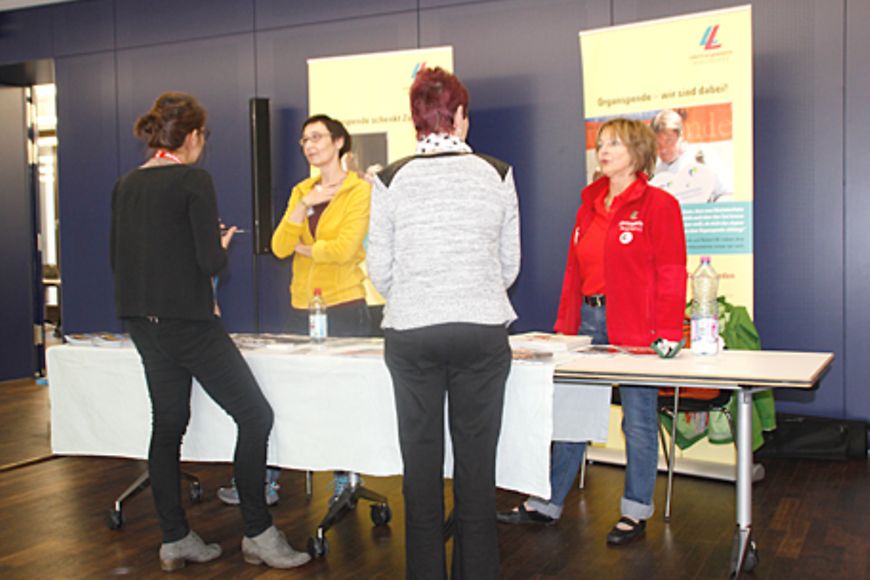 Zwei Frauen stehen vor einem Stand und informieren sich über Organspende, Bildnachweis: BMFSFJ