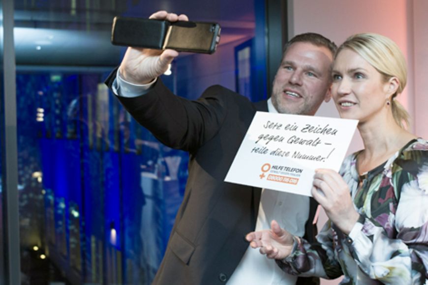 Ein Mann macht mit seinem Smartphone ein Selbstporträt von sich und Manuela Schwesig