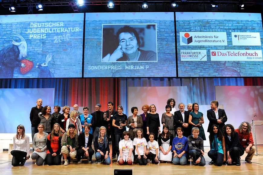 Gruppenfoto auf einer Bühne. Bildnachweis: Arbeitskreis für Jugendliteratur/ José Poblete
