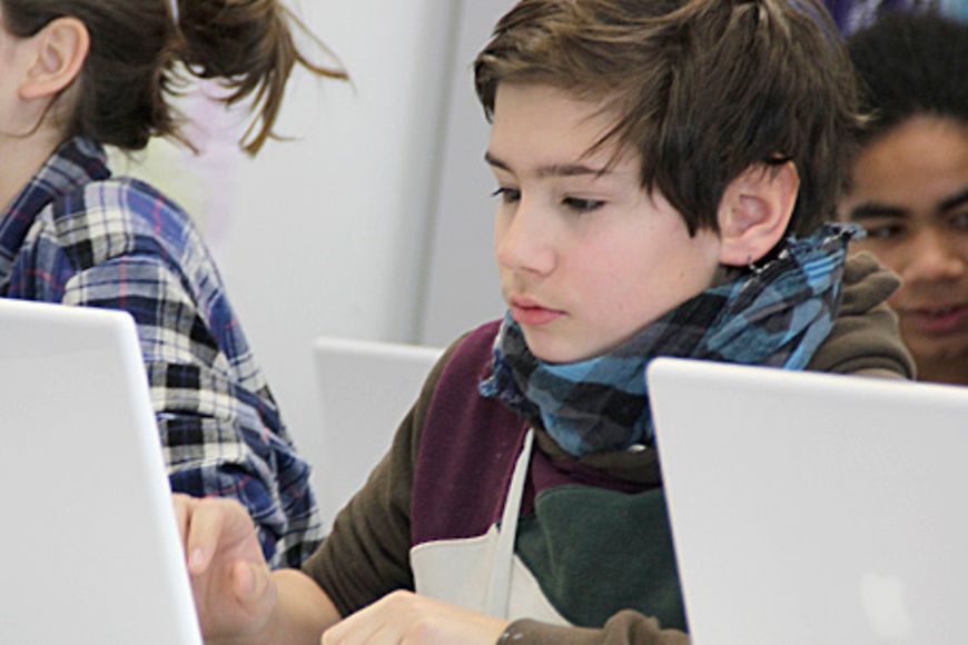 Ein Schüler sitzt vor einem Laptop