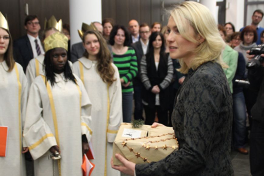 Manuela Schwesig übergibt eine Spendenbox an die Sternsinger