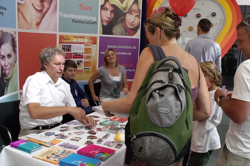 Eine Frau informiert sich an einem Stand. Bild: BMFSFJ