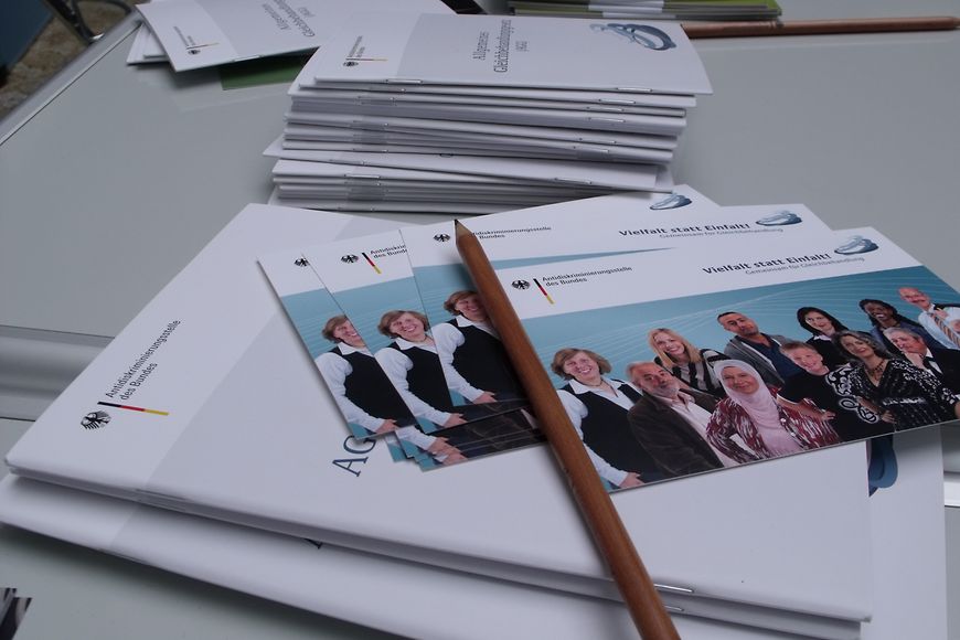 Broschüren und Stifte liegen auf einem Tisch. Bild: BMFSFJ
