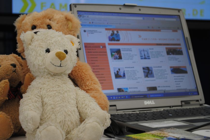 Ein Teddybär sitzt vor einem PC-Bildschirm. Bild: BMFSFJ