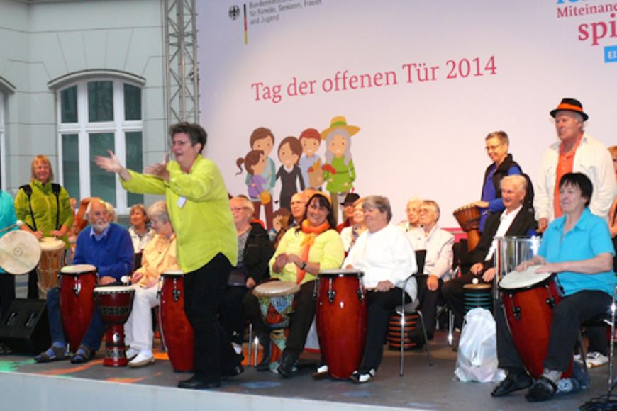 Senioren stehen auf der Bühne und trommeln